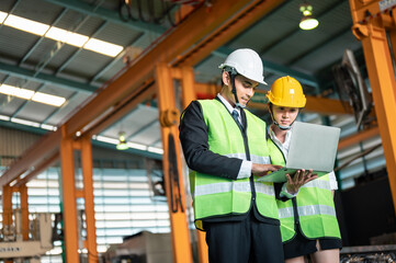 facility, engineer, helmet, display, architect, safety, manufacturing, blueprint, discussion, hard hat. Two men in safety gear are looking at a laptop. They are discussing information or safety.