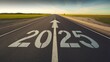 © Caspernik - Road to 2025 with an empty road with written 2025 and arrow pointing towards the horizon to represent the future and positivity and success of the new year 2025