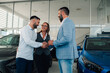 © Zamrznuti tonovi - Happy couple finalizes deal with dealership expert in showroom