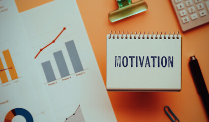 There is notebook with the word Motivation. It is as an eye-catching image.