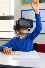 Wall Mural - Using VR headset, boy raising hand in classroom, engaging in school activity