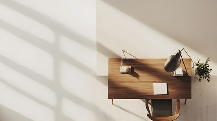 Poster - A birds-eye view of a minimalist workspace with a simple wooden desk, a single chair, and a lamp, set against a white wall.