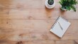 © cynz - An overhead view of a minimal indoor workspace featuring only a simple notebook and pen on a wooden desk.