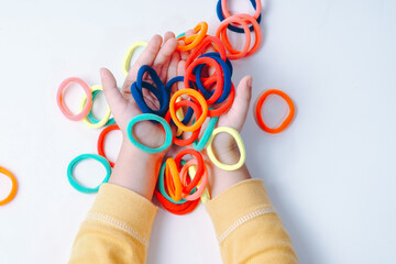 hand holding Colorful elastic hair ties, Multicolored elastics , isolated on white background