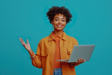 A woman in an orange jacket is holding a laptop