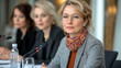 © feeling lucky - Female leader at a conference table, engaged in discussion with colleagues, showcasing professionalism and collaboration.