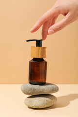 Wall Mural - Cosmetic oil in a brown bottle with pebbles