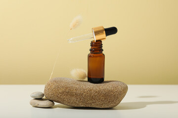 Wall Mural - Cosmetic oil in a brown bottle with a pebble