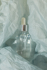 Wall Mural - Cosmetic oil in a transparent bottle on a light background