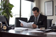 © dK - Businessman reviewing important documents in a professional office environment, carefully reading through reports for decision-making and project evaluation