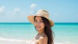 © Hathairat - Smiling woman in a hat enjoying a sunny day at the beach.
