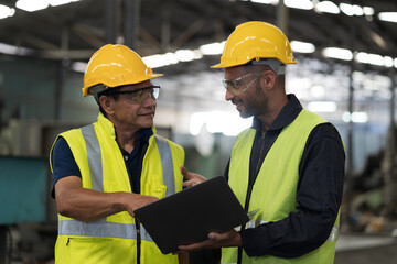 Two male engineer worker discuss and working together in industry factory. Male engineer repairing or maintenance CNC machine in factory