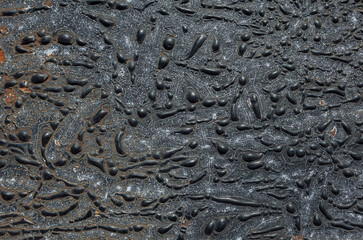 Dark abstraction background, Pattern of swollen bubbles of old blistered black paint on a metal rusty surface, looks like abstract art or reptile leather