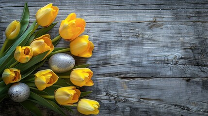 Easter theme with silver eggs yellow tulips on wooden backdrop Overhead view with room for text