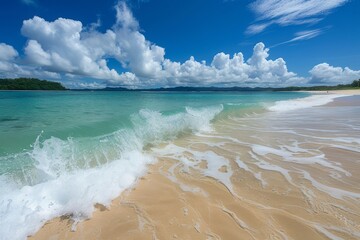 Serene ocean waves gently lap against the sandy shore under a bright blue sky during a sunny day at the beach