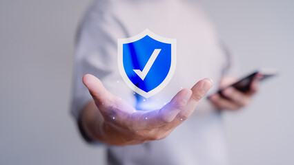 Fototapete - Person holds a glowing shield with a checkmark icon, symbolizing security, protection, and trust. Concept of emphasizes digital safety, authentication, and confidence in modern technology.