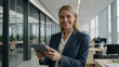 © Tengkwa - Confident Businesswoman: A portrait of a confident businesswoman in a modern office setting, holding a tablet and smiling warmly at the camera.