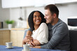 © Antonioguillem - Happy interracial couple looking each other in love in the kitchen