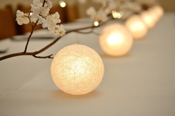 A row of glowing globe lights resting on a minimalist white table creating a modern and festive holiday lighting display indoors