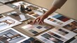 © hobonski - Careful Selection of Color Palettes for Design Project. A close-up view of an interior designer's hand picking a color swatch from an array of samples on a cluttered workspace.