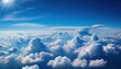 bright cloudy sky view from airplane. White clouds on blue sky background close up, cumulus clouds high in azure skies, beautiful aerial cloudscape view from above.