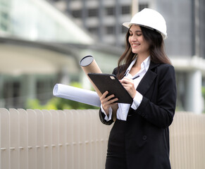 Engineer, architect woman working on housing real estate development project in urban. Female property development designer hold blueprint of residential apartment layout sketch for structure builder