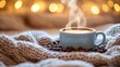 © orendesain99 - A steaming cup of coffee on a cozy blanket with coffee beans.