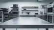 © orendesain99 - Closeup of a clean, shiny stainless steel countertop in a professional kitchen. The countertop is positioned in the foreground with blurred appliances in the background.