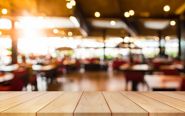 Wall Mural - Empty wooden table top with lights bokeh on blur restaurant background.	