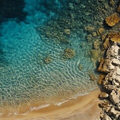 Wall Mural - A view of a sandy beach with clear blue water and rocks