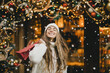 © polinaloves - Young beautiful womam enjoying Christmas shopping on a decorated street.