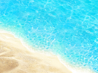 the waves of summer sandy beach and emerald green sea seen from above.