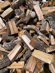 Firewood background concept: a pile of chopped oak wood ready to be used in wood stoves and fireplaces