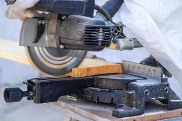 A man cuts wood with a sawmill. Selective focus.