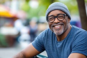 Wall Mural - A man wearing a blue shirt and a gray hat is smiling