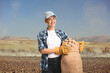 © Ljupco Smokovski - Young female farmer holding potatoes in a sack