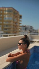 Wall Mural - Enjoying a peaceful and relaxing time by the beautiful pool while wearing a stylish pink bikini