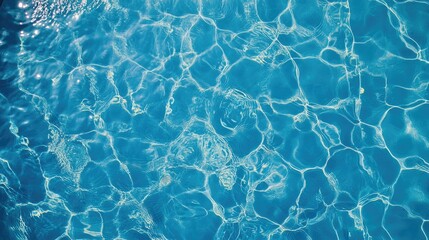 Water ripples create patterns on a blue tiled swimming pool surface Aerial perspective