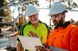 © Austockphoto - Two construction site managers looking at digital blueprints on tablet device