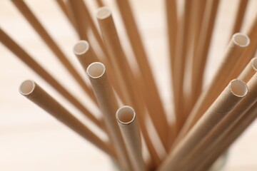 Wall Mural - Bamboo drinking straws on beige background, closeup