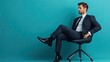 © Sumet - A confident businessman sitting in a stylish office chair against a vibrant blue background, exuding professionalism and charm.