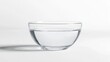 © Nathan - A clear glass bowl filled with still water, showcasing its simplicity and purity against a light background.