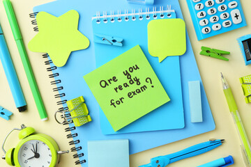 Sticker - Paper note with question Are You Ready For Exam and stationery on pale yellow background, flat lay