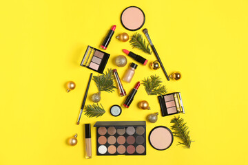 Wall Mural - Christmas tree made with makeup products and festive decor on yellow background, flat lay