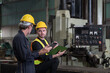 © amorn - Two male engineer checking, repair, maintenance CNC machine in factory. Group of male technician working with CNC machine during manufacturing process