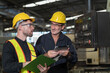 © amorn - Two male engineer checking, repair, maintenance CNC machine in factory. Group of male technician working with CNC machine during manufacturing process