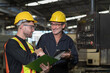 © amorn - Two male engineer checking, repair, maintenance CNC machine in factory. Group of male technician working with CNC machine during manufacturing process