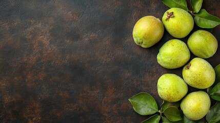 Fresh green pears arranged with leaves on a textured surface.