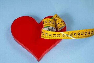 red heart shape with measuring tape symbolizing health care