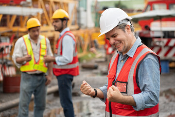 Wall Mural - Cheer Mature caucasian engineer man worker with team and spare crane background	